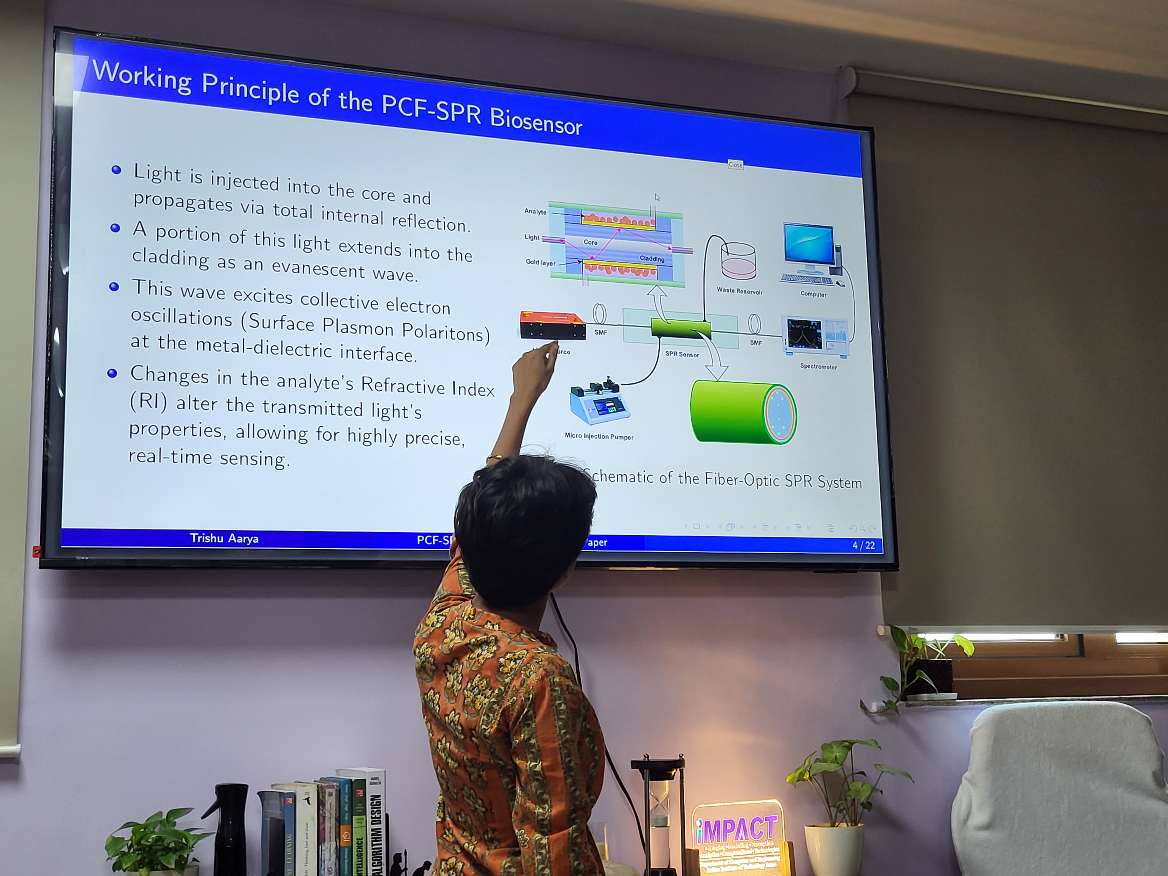 Researcher presenting the working principle of a PCF-SPR biosensor